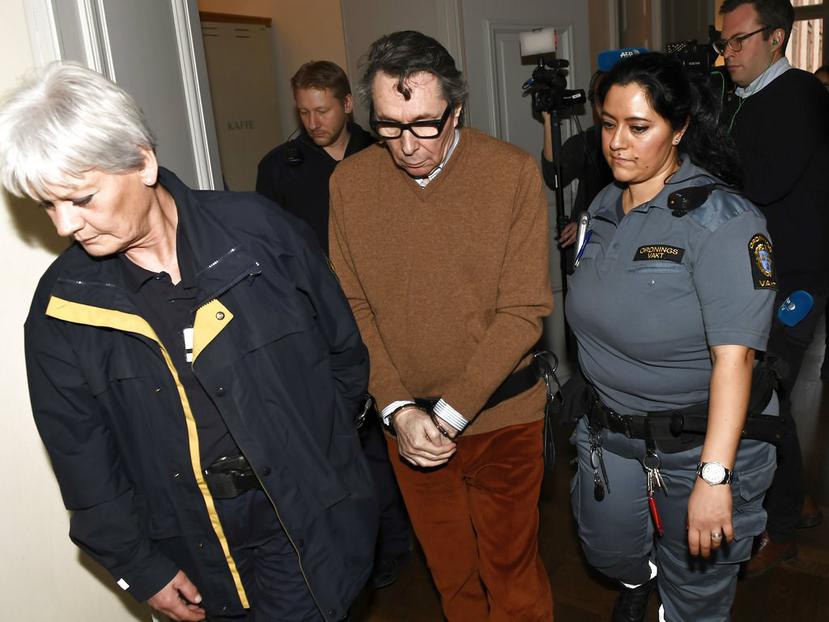Jean-Claude Arnault (centro) es escoltado por dos policías en un tribunal de la ciudad de Estocolmo, Suecia. (AP)