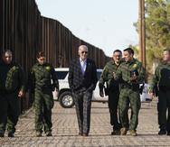 El presidente Joe Biden camina con agentes de la Patrulla Fronteriza en un tramo de la frontera con México.