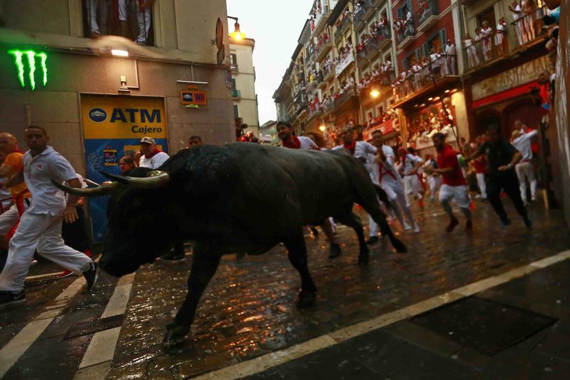 Un grupo de mozos corre junto a toros de la ganadería José Escolar en el segundo encierro de las fiestas de San Fermín. (AP)