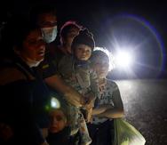 ARCHIVO - En esta fotografía del 17 de mayo de 2021 se muestra un grupo de migrantes procedentes de Honduras y Nicaragua que esperan en un camino luego de que se entregaron a las autoridades en La Joya, Texas. (AP Foto/Gregory Bull, Archivo)