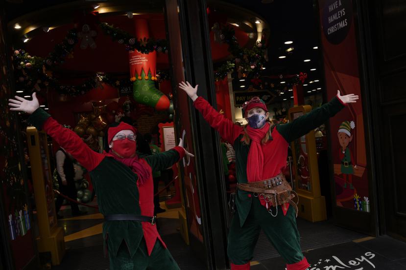 Empleados de una juguetería reciben a los compradores en la tienda de Regent Street, en Londres, el viernes 24 de diciembre de 2021.