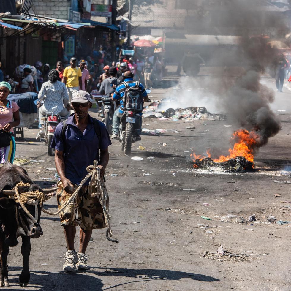 Vista de un mercado informal donde humean restos de neumáticos, debido a la protesta de los policías, en Puerto Príncipe, Haití. EFE/Johnson Sabin