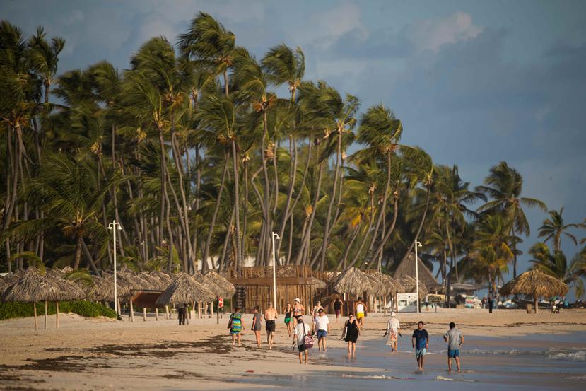 Turistas caminan por playa Bávaro en Punta Cana. (EFE)