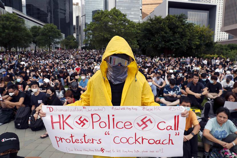 Un manifestante prodemocrático sostiene una pancarta ilustrada con esvásticas en la que se lee "la policía de Hong Kong califica a los manifestantes de cucarachas". (EFE)