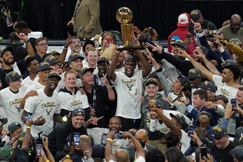 Kris Middleton alza el trofeo de campeonato de la NBA junto a los Bucks de Milwaukee.