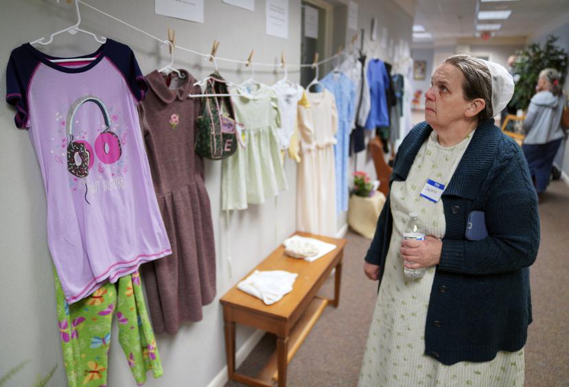 Darlene Shirk observa una muestra de ropa que lucían víctimas de abusos sexuales menores de edad en las comunidades amish, menonitas y otras en un seminario sobre prevención del abuso infantil en Leola, Pensilvania.