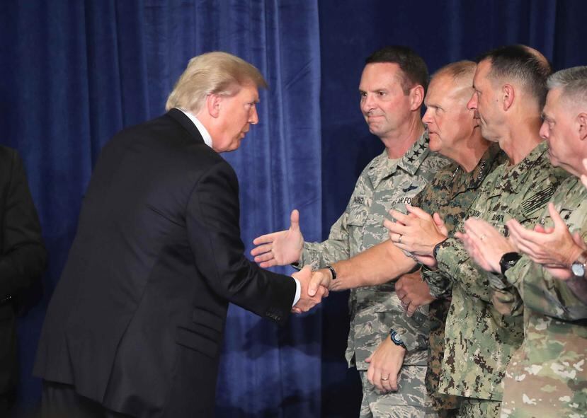 El presidente Donald Trump saluda un grupo de militares estadounidenses. (EFE)