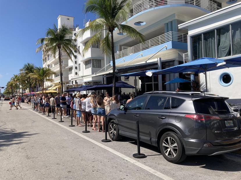 Varios jóvenes esperan para entrar a un establecimiento en la calle Ocean Drive, durante el Spring Break, en Miami.