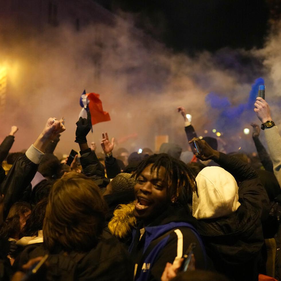Seguidores de Francia reaccionan junto al Arco del Triunfo en la avenida de los Campos Elíseos al término del partido de semifinales del Mundial de fútbol entre Francia y Marruecos, en París, el miércoles 14 de diciembre de 2022. (AP Foto)