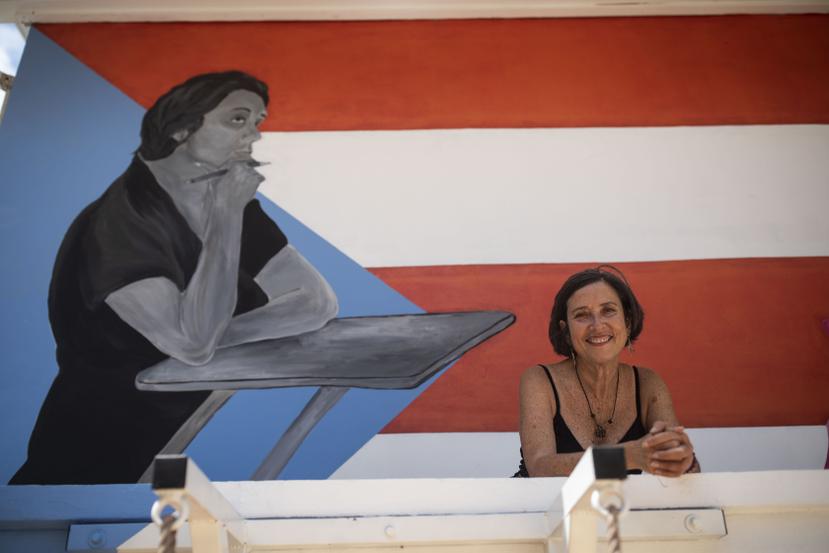 María Teresa Mejía Valle posa, en el Museo de Historia y Cultura de Camuy, frente al mural creado en honor a su madre, Margot Valle Hernández, quien fue asesinada junto a otras cinco personas en medio de un incidente de violencia doméstica.