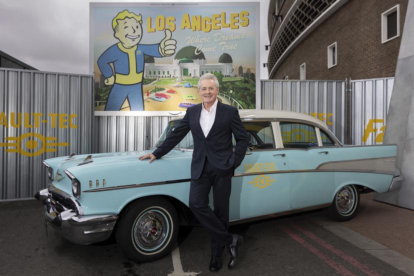 Kyle MacLachlan posa junto a un carro de la época a su llegada a la premiere of de la serie "Fallout" el jueves 4 de abril de 2024 en Londres donde además se aprecia a Vault Boy en el trasfondo. (Foto Vianney Le Caer/Invision/AP)
