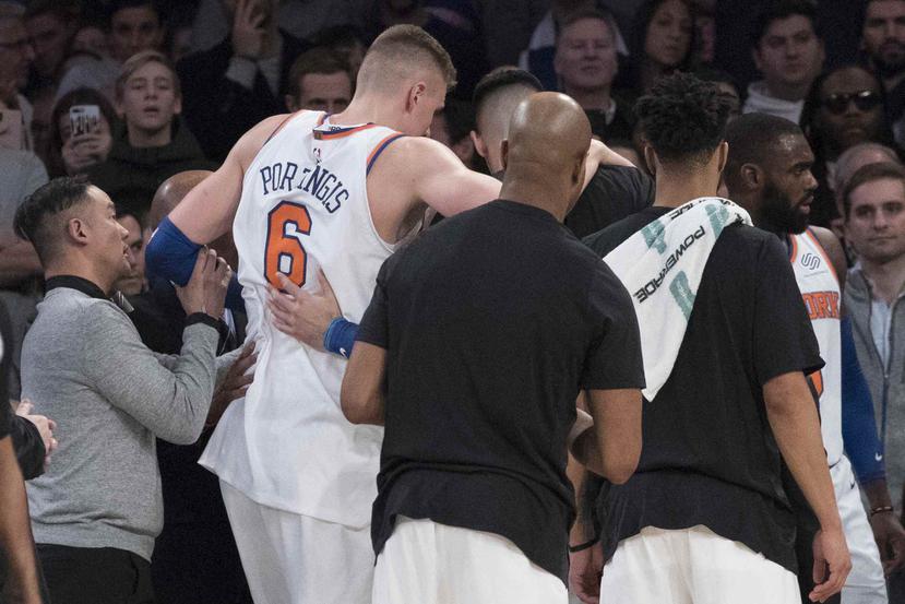 El jugador de los Knicks, Kristaps Porzingis, sale de la cancha tras lesionarse en un partido contra los Bucks. (AP)