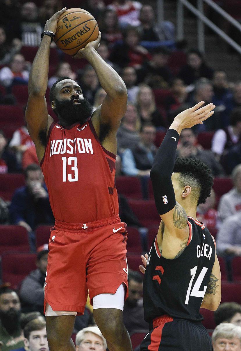 El escolta de los Rockets de Houston, James Harden (13), hace un tiro a la canasta sobre la marcación del escolta de los Raptors de Toronto, Danny Green (14), durante la segunda mitad de un juego de la NBA. (AP)