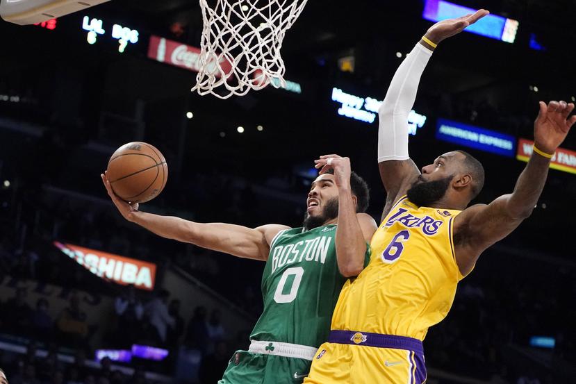 El jugador de los Celtics de Boston Jayson Tatum (0) tira al canasto mientras el LeBron James (con el 6) defiende en la primera mitad de su juego de NBA el martes, 7 de diciembre de 2021, en Los Ángeles.