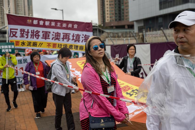 Manifestantes en Hong Kong protestan mientras son obligados por la Policía de esa ciudad a utilizar identificadores y no taparse la cara con mascarillas como parte de las normas para aprobar la protesta