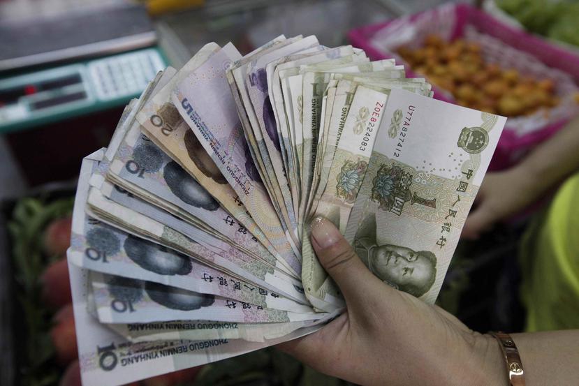 Una vendedora muestra billetes de yuan en Pekín, China. (EFE)