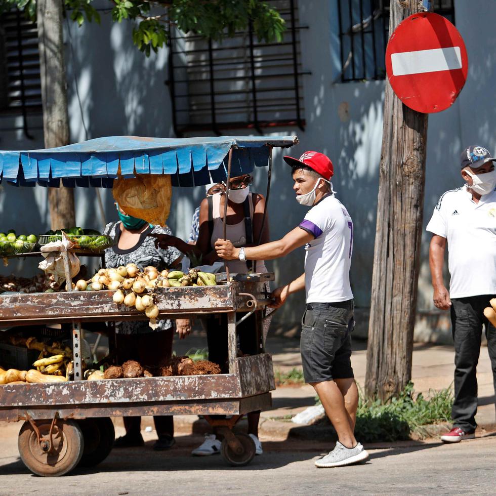 Varias personas hablan junto a un carretillero que vende productos agrícolas este martes, en La Habana. (Agencia EFE)