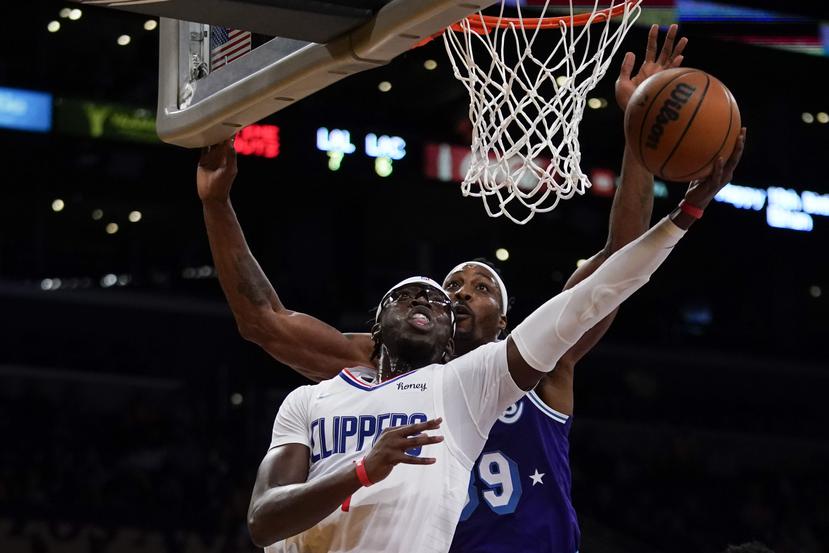 Reggie Jackson (1) de los Clippers dispara contra el centro Dwight Howard (39) de los Lakers durante la primera mitad de un juego de baloncesto de la NBA en Los Ángeles, el viernes 3 de diciembre de 2021.