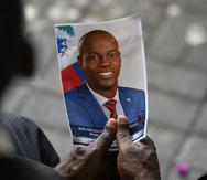Una persona sostiene una fotografía del difunto presidente Jovenel Moïse durante una ceremonia fúnebre el 20 de julio de 2021, en el Museo y Cementerio Nacional en Puerto Príncipe, Haití.