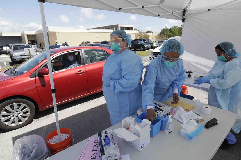 Personal realiza pruebas de coronavirus a través de un servicarro en Miami. (AP)