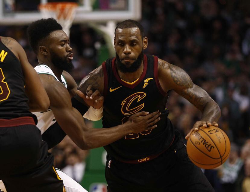 El jugador LeBron James (derecha) de Cleveland Cavaliers protege el balón ante la marca de Jaylen Brown de Boston Celtics en el partido del miércoles 3 de enero de 2018). (EFE)