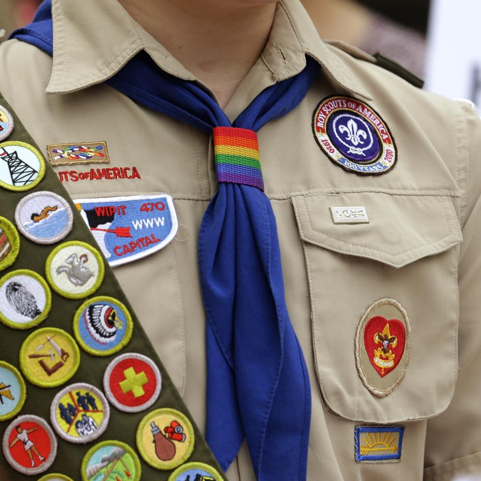 Insignias de mérito y un pañuelo con los colores del arcoíris en el uniforme de un niño explorador.