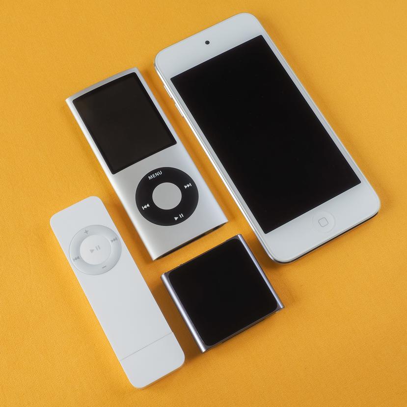 La imagen muestra diversos modelos de la línea iPod, como el iPod Shuffle, dos unidades distintas del iPod Nano y el iPod Touch.