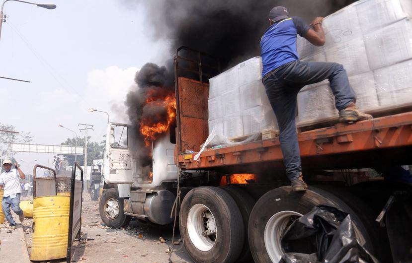 Personas intentan remover parte de la ayuda humanitaria transportado por un camión que fue quemado el pasado 23 de febrero. (EFE / Deibison Torrado)
