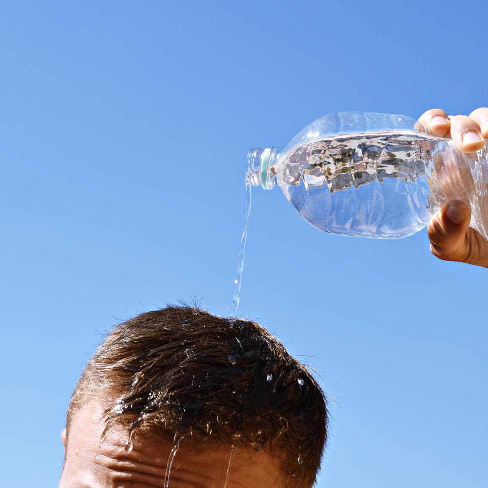 Un hombre se echa agua por encima de la cabeza ante la alta sensación de calor.