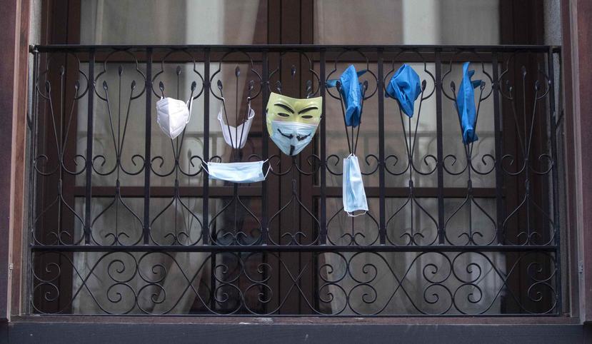 Mascarillas faciales y guantes cuelgan de un balcón en Madrid, España. (AP)