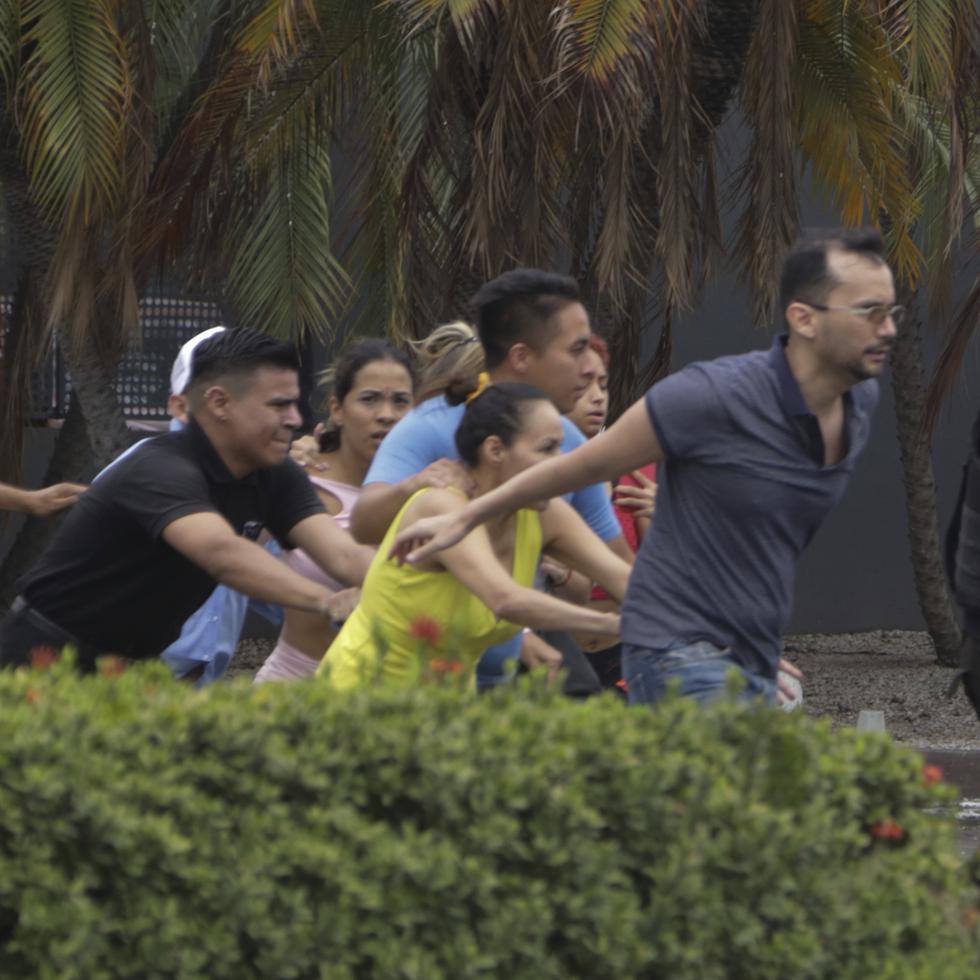 La policía evacúa a personal del canal TC Televisión después de que un grupo armado y encapuchado irrumpiera en plena transmisión en directo, en Guayaquil, Ecuador.