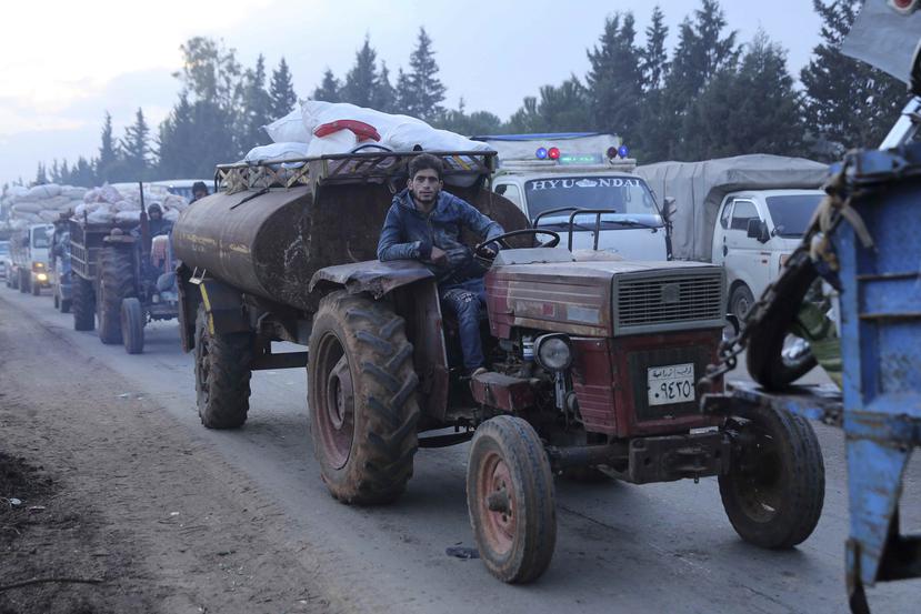 Un hombre conduce un tractor cerca de la localidad de Hazano mientras miles de civiles huyen de una ofensiva militar del gobierno sirio en la provincia de Idlib, el último bastión rebelde en Siria, el martes 24 de diciembre de 2019. (AP / Ghaith al-Sayed)