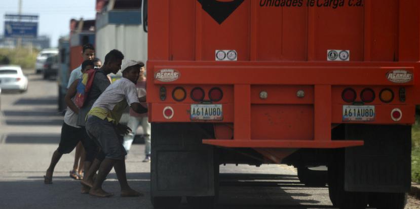Un grupo de hombres intenta robar arroz de un camión de carga que llega al puerto de Puerto Cabello, Venezuela. (AP)