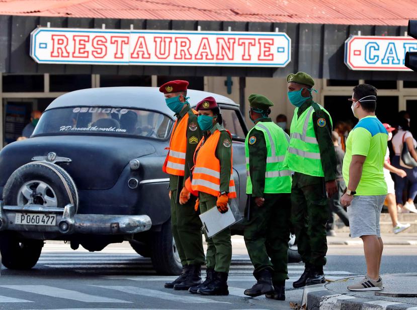 Guardias en La Habana usan mascarillas. (Agencia EFE)