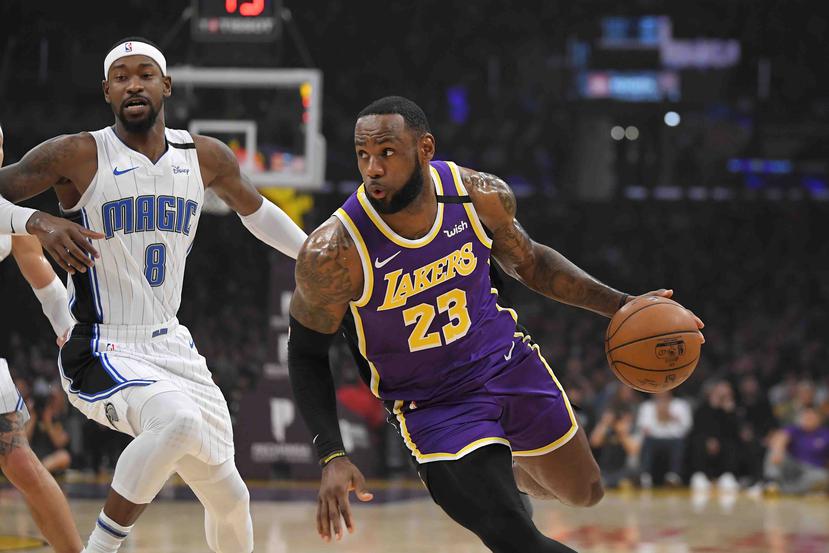 LeBron James de los Lakers de Los Ángeles se acerca a la canasta mientras Terrence Ross del Magic de Orlando defiende durante la primera mitad de su juego NBA. (AP/Mark J. Terrill)