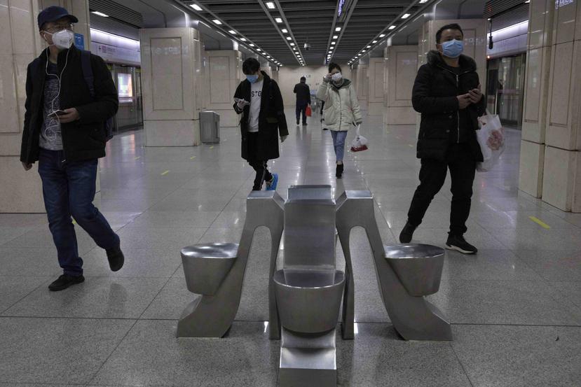 Personas caminan en una estación del metro de Wuhan en China. (AP)