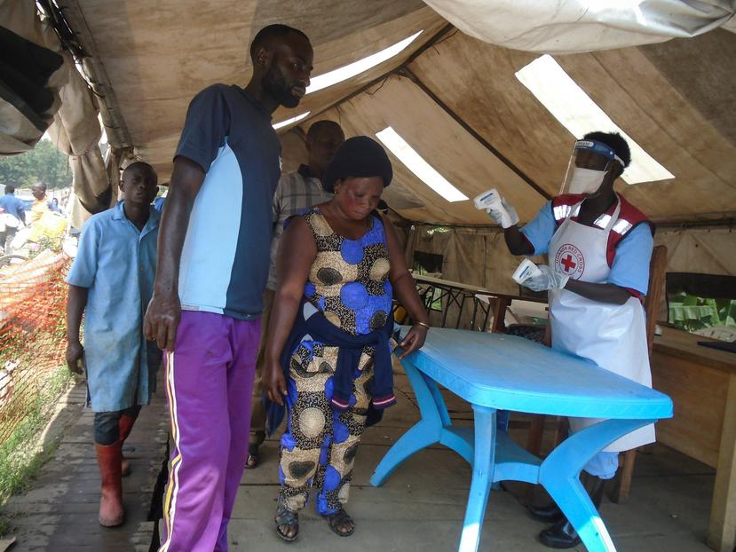 Los trabajadores de la Cruz Roja examinan a las personas que cruzan la frontera hacia Uganda desde la República Democrática del Congo. (EFE)