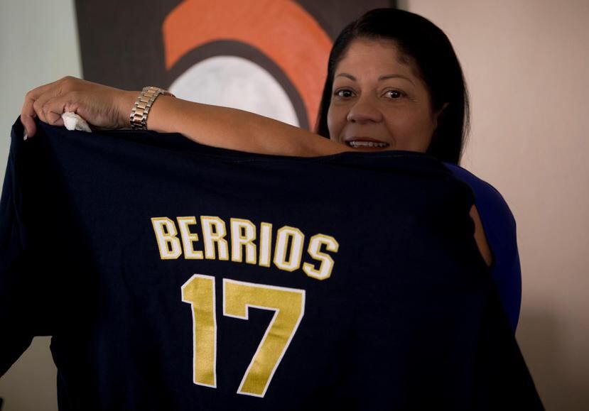 Magaly Torres sostiene una de las camisas que vestirán los familiares y amigos de José Berríos para los partidos del martes y miércoles en el estadio Hiram Bithorn.