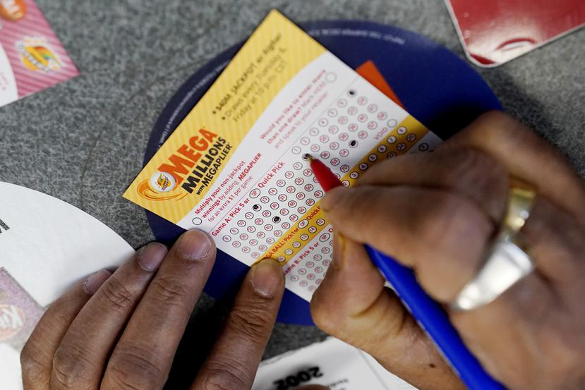 Un cliente llegan un boleto de lotería Mega Millions.