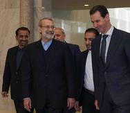 El presidente Siria, Bashar Assad (derecha), habla con el presidente del parlamento iraní, Ali Larijani, en Damasco, Siria. (SANA via AP)