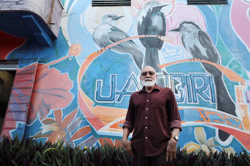 Rubén Malavé frente al mural que ocupa la fachada de la galería Guatíbiri, en Río Piedras. El mismo fue creado  por Yehimar Ureña Medina.
