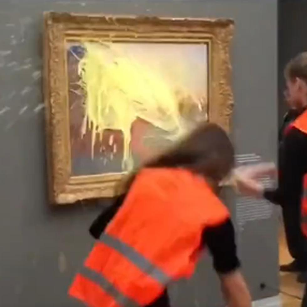 Momento en que dos activistas lanzan un puré de papas contra un cuadro de Monet cerca de Berlín, Alemania.