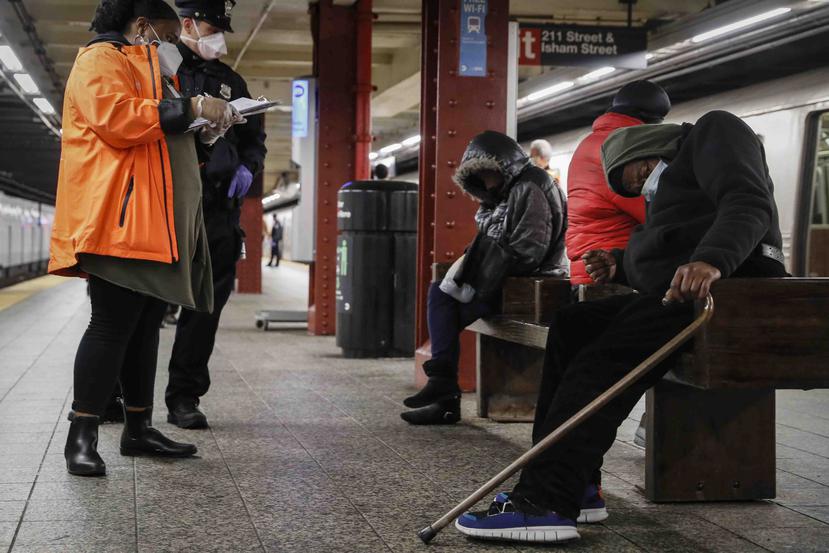 En esta foto de archivo del 30 de abril de 2020, personal municipal de Nueva York asiste a indigentes que duermen en estaciones del metro. (AP Foto/John Minchillo)
