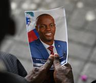 Una foto de archivo muestra a una persona sosteniendo una foto del asesinado presidente de Haití Jovenel Moise.