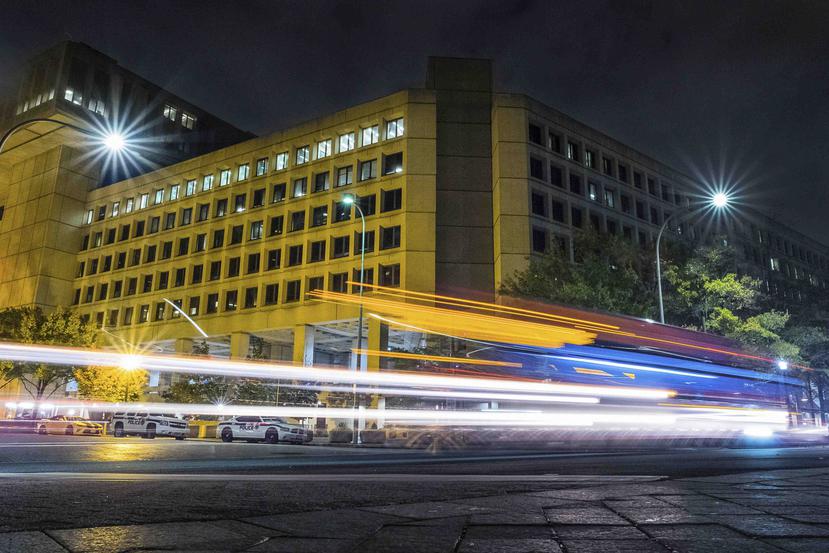 Un vehículo dibuja estelas de luz al pasar por la Avenida Pennsylvania en Washington frente a las oficinas generales del FBI. (AP)