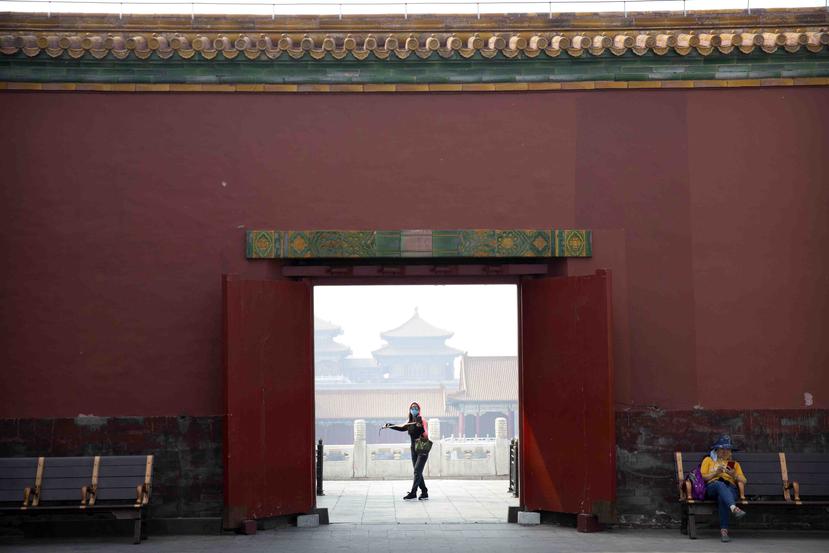 Un visitante, con mascarilla para protegerse del coronavirus, pasea por la Ciudad Prohibida, en Beijing, el 1 de mayo de 2020. (AP Foto/Mark Schiefelbein)

