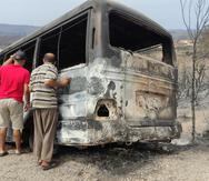 Un autobús incendiado a consecuencia de fuegos forestales en Argelia.