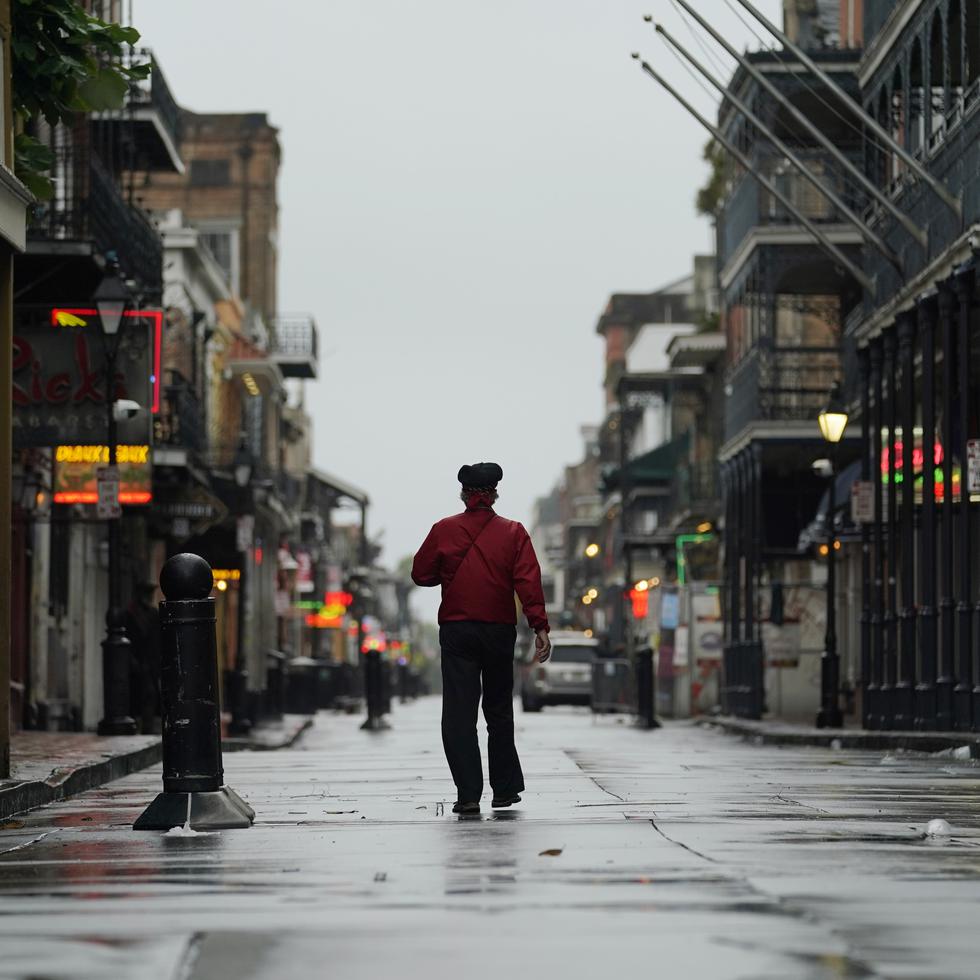 Un hombre camina sobre la calle Bourbon en el distrito francés antes de la llegada del huracán ida, el domingo 29 de agosto de 2021, en Nueva Orleans. AP Foto/Eric Gay)