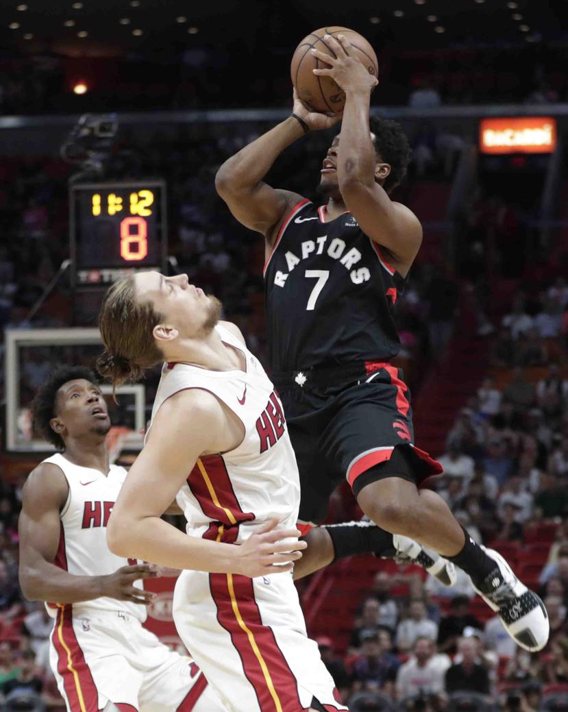 El escolta de los Raptors de Toronto, Kyle Lowry, se apresta a tomar un disparo ante la defensa del delantero Kelly Olynyk. (AP / Lynne Sladky)