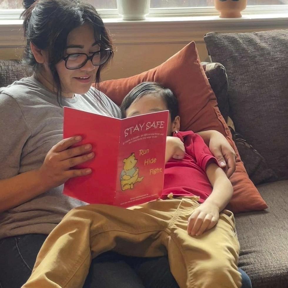 Cindy Campos lee "Stay Safe" a su hijo de 5 años, en Dallas. El libro aconseja a los niños qué hacer si "el peligro está cerca", como cerrar puertas con llave, apagar las luces y esconderse en silencio hasta que llegue la policía. (Cindy Campos vía AP)